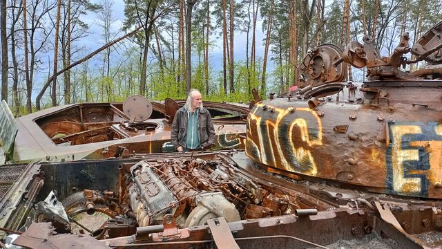 Kněz Ladislav Heryán uprostřed opuštěné ruské techniky u města Buča. Foto: Jan Blažek