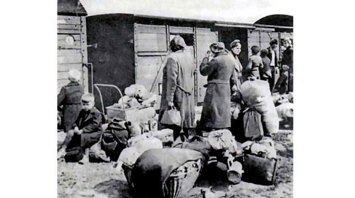 Lidé s osobními věcmi čekají na odsun z Československa. Archiv Jindřicha Nového.