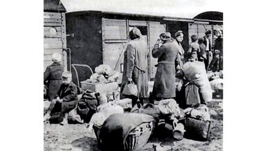 Lidé s osobními věcmi čekají na odsun z Československa. Archiv Jindřicha Nového.