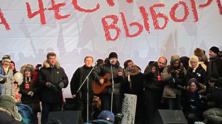Jurij Ševčuk, frontman skupiny DDT, zpívá na opozičním shromáždění v Moskvě v únoru 2012. Po napadení Ukrajiny veřejně odmítl válku a stal se jedním z nejvýraznějších hlasů ruské hudební scény proti invazi. Foto: Bogomolov.PL / Wikimedia Commons, CC BY-SA 3.0
