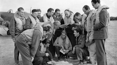 Letci 310. čs. perutě na letišti Duxfordu v září 1940. Na fotografii: Václav Bergman, Bohumír Furst, Rudolf Zima, Emil Fechtner, Stanislav Zimprich, Jan Kaucký, Karel Šeda, Jaroslav Malý, Vilém Goth, Josef Vopalecký, Svatopluk Janouch, Raimund Půda, Gordon Sinclair, John Boulton and Jerrard Jeffries. Foto: Imperial War Museums