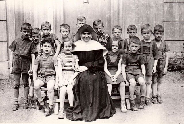  Sestra Paulína Doušová se svými svěřenci ve smíchovském ústavu pro neslyšící roku 1955 krátce předtím, než byla donucena svou činnost ukončit. Zdroj: archiv Paulíny Doušové. 